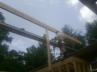 Carpenter setting a ridge beam over a new addition frame — Ice Dam Removal by Roofing Brothers in Licking