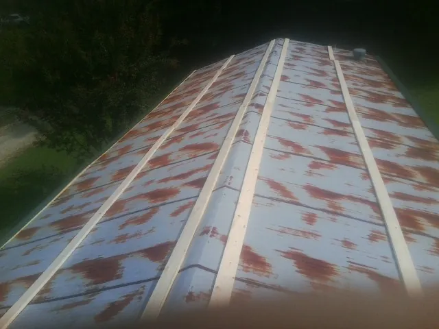 Rusted metal roof panels with new wood purlins before replacement — Storm Damage Roof Repair in Licking by Roofing Brothers