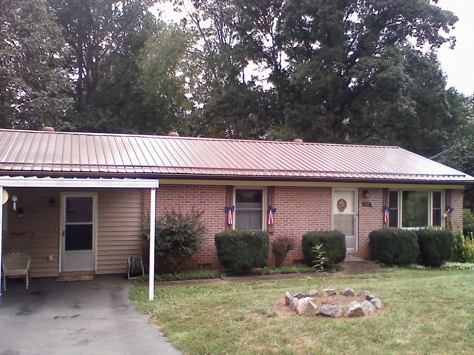Bronze metal roof and carport on a brick ranch home — Roof Repair work by our crew in Licking